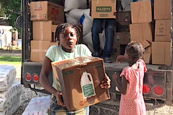 girl receiving a box of donations from distribution