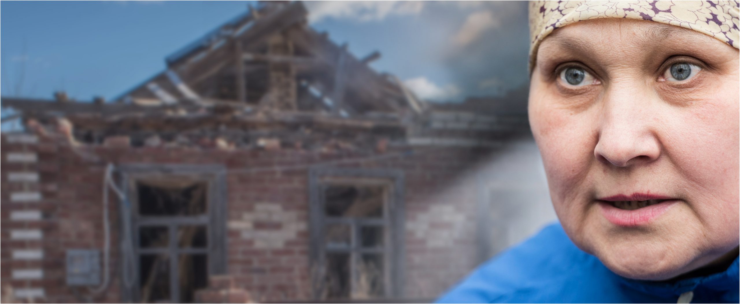 woman in front of house in ruins